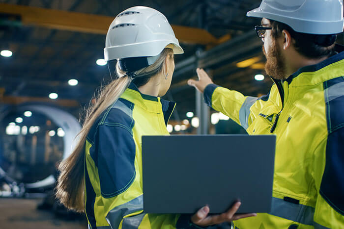 innovation-individuelle-anlagen Eine Frau und ein Mann besprechen die Planung einer Anlage in einer Industriehalle