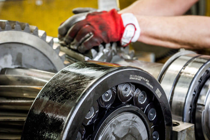 services-repair-gearboxes Person wearing gloves works on a gearbox that is in focus