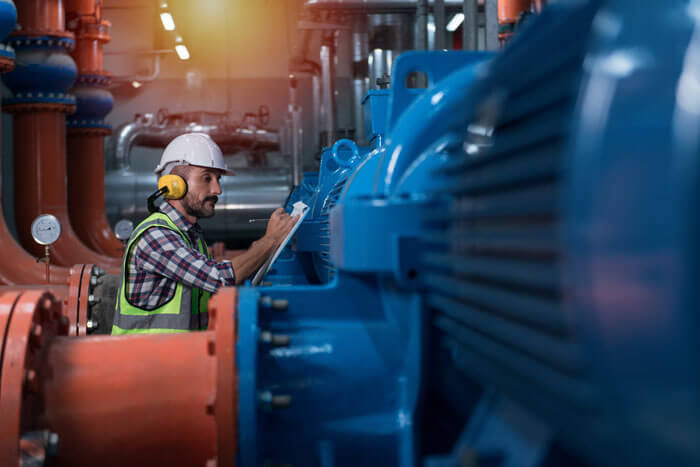 Arbeiter in Industrieanlage bei der Überprüfung vor Ort