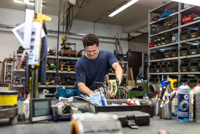leistungen-kran-reparatur-instandsetzung-werksatt Reparatur eines Kranteils in unserer Werkstatt durch einen Mitarbeiter
