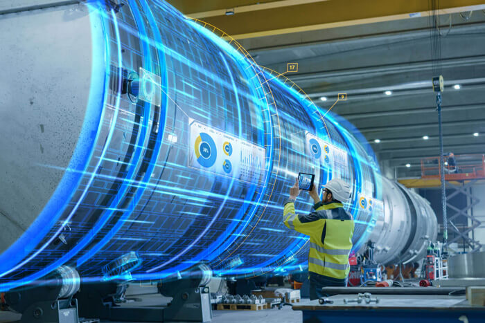 Person untersucht eine große Metall-Pipeline mit einem Tablet. Es ergeben sich holografische Linien um das Objekt.